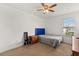 Minimalist bedroom with neutral carpeting, ceiling fan, natural light, and a simple chair at 4869 Grassendale Ter, Sanford, FL 32771