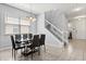 Well-lit dining room with a contemporary table, a stylish chandelier, and easy access to the staircase and front entrance at 4869 Grassendale Ter, Sanford, FL 32771