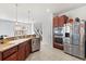 Open-concept kitchen featuring stainless steel appliances, tile floors, granite countertops, and a view into the living area at 4869 Grassendale Ter, Sanford, FL 32771