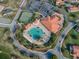 Aerial view of the pool, clubhouse, tennis courts and pristine landscaping at 4976 Sandpiper Dr, Oxford, FL 34484