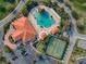 Stunning aerial view showcasing the resort-style pool, clubhouse, tennis courts and lush landscaping at 4976 Sandpiper Dr, Oxford, FL 34484