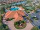 Aerial view of the community clubhouse with pool, tennis courts, and beautifully landscaped grounds at 4976 Sandpiper Dr, Oxford, FL 34484