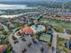 Community aerial view showcasing pool, clubhouse, tennis courts, parking, and scenic water views at 4976 Sandpiper Dr, Oxford, FL 34484