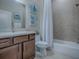 Well-lit bathroom featuring a tub-shower combo with a decorative vanity and nautical decor at 4976 Sandpiper Dr, Oxford, FL 34484