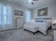 Comfortable bedroom with ceiling fan, carpet floors, white walls, and bright windows at 4976 Sandpiper Dr, Oxford, FL 34484