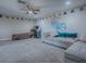 Spacious bonus room featuring carpet, a sectional sofa, and arcade games at 4976 Sandpiper Dr, Oxford, FL 34484
