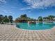 Large community pool featuring a rock grotto and expansive deck space at 4976 Sandpiper Dr, Oxford, FL 34484