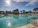 Large community pool with sun-drenched deck offers a rock feature, and clear blue water at 4976 Sandpiper Dr, Oxford, FL 34484