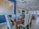Stylish dining room with seating for six, set against a blue accent wall leading to a comfortable living area at 4976 Sandpiper Dr, Oxford, FL 34484