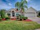 Charming home with manicured front yard, lush landscaping, brick accents and a two-car garage at 4976 Sandpiper Dr, Oxford, FL 34484