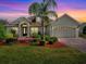 Charming single-story home with a well-manicured lawn and a paver driveway leading to a two-car garage at 4976 Sandpiper Dr, Oxford, FL 34484