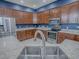 Well-equipped kitchen with stainless steel appliances, dark wood cabinets, and light countertops for meal preparation at 4976 Sandpiper Dr, Oxford, FL 34484