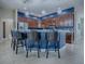 Modern kitchen featuring dark cabinetry, stainless steel appliances, a central island with bar seating, and pendant lighting at 4976 Sandpiper Dr, Oxford, FL 34484