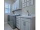 This laundry room has a sink and counter, as well as a modern washer and dryer at 4976 Sandpiper Dr, Oxford, FL 34484