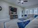 Inviting living room featuring a comfortable sectional sofa, ceiling fan and stylish entertainment center at 4976 Sandpiper Dr, Oxford, FL 34484
