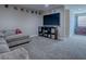 Cozy living room features plush carpeting, media center, and a large flat screen TV for entertainment at 4976 Sandpiper Dr, Oxford, FL 34484