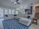 Bright and spacious living area with a large sofa, blue accent pillows, and open access to the kitchen and dining areas at 4976 Sandpiper Dr, Oxford, FL 34484