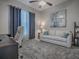 This office is carpeted and has a window with curtains, a couch, and a ceiling fan at 4976 Sandpiper Dr, Oxford, FL 34484