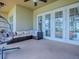 Relaxing screened patio features a modern ceiling fan, egg chair, and comfortable wicker sofa at 4976 Sandpiper Dr, Oxford, FL 34484