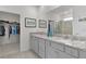 Bright bathroom features dual sinks, granite counters, and a walk-in shower at 5043 Stokes Way, Wildwood, FL 34785