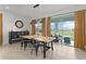 Bright dining room with modern light fixtures, a wooden table set, and sliding glass doors to a covered patio at 5043 Stokes Way, Wildwood, FL 34785
