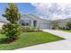Alluring single-story home boasting a vibrant green lawn and a practical two-car garage at 5043 Stokes Way, Wildwood, FL 34785