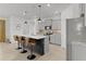 Open kitchen with a black island, granite countertops, stainless steel appliances, and three bar stools at 5043 Stokes Way, Wildwood, FL 34785