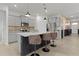 Modern kitchen with a black island, granite countertops, stainless steel appliances, and brown leather bar stools at 5043 Stokes Way, Wildwood, FL 34785
