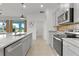 Bright kitchen with stainless steel appliances, granite countertops, and views to the dining area and outdoor scenery at 5043 Stokes Way, Wildwood, FL 34785