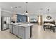 Open concept living space featuring a modern kitchen, a dining area, and a cozy living room with a TV at 5043 Stokes Way, Wildwood, FL 34785