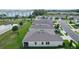 Aerial perspective of the home's rear with a screened-in porch near a pond and other neighborhood homes at 5043 Stokes Way, Wildwood, FL 34785