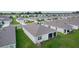 Aerial view of the rear exterior featuring a screened-in lanai and well-maintained lawn in a residential neighborhood at 5043 Stokes Way, Wildwood, FL 34785