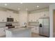 Modern kitchen with white cabinetry, stainless steel appliances, granite countertops and an island with a sink at 5045 Balsam Falls Rd, Deland, FL 32724