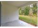 Covered patio with concrete flooring offers outdoor living space, looking to the tree-lined yard at 5045 Balsam Falls Rd, Deland, FL 32724