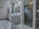 Bathroom featuring a glass shower, soaking tub, gray vanity and modern finishes at 5905 Caulk Ct, The Villages, FL 32163