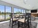 Dining area in sunroom featuring modern table set with water view, next to the living space at 5905 Caulk Ct, The Villages, FL 32163