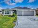 Charming home features a well-manicured lawn and a spacious three-car garage at 5905 Caulk Ct, The Villages, FL 32163