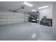 Spacious garage with epoxy flooring, golf cart, storage cabinets and overhead lighting at 5905 Caulk Ct, The Villages, FL 32163