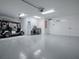 Well-lit garage with epoxy flooring, modern cabinets, golf cart and storage units at 5905 Caulk Ct, The Villages, FL 32163