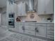 Well-equipped kitchen with gray cabinets, stainless steel appliances, and ample counter space at 5905 Caulk Ct, The Villages, FL 32163