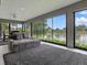 Bright sunroom offers stunning lake views with a cozy sitting area and stylish gray color scheme at 5905 Caulk Ct, The Villages, FL 32163