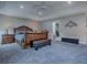 Elegant main bedroom with a large leather bed frame and a view into the main bathroom at 5905 Caulk Ct, The Villages, FL 32163
