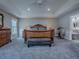 Comfortable main bedroom with carpeting, exercise bike, trey ceilings, and ensuite bathroom at 5905 Caulk Ct, The Villages, FL 32163