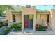 Inviting exterior of condo with steps to the red front door, landscaped plants, and carport on the side at 601 W Old Hwy 441 # 11B, Mount Dora, FL 32757