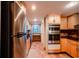 Spacious kitchen featuring stainless steel appliances, wooden cabinets, and tiled floors at 601 W Old Hwy 441 # 11B, Mount Dora, FL 32757