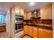Well-lit kitchen equipped with stainless steel appliances, wood cabinetry, and granite countertops at 601 W Old Hwy 441 # 11B, Mount Dora, FL 32757