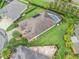 Beautiful aerial view of a well-maintained home featuring a screened-in pool and meticulous landscaping at 631 Independence Path, The Villages, FL 32163