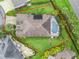 Stunning aerial view of home with lush landscaping and a sparkling screened-in pool at 631 Independence Path, The Villages, FL 32163