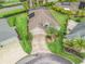 Aerial view of home on a well-manicured lot with lush landscaping and a circular driveway at 631 Independence Path, The Villages, FL 32163