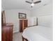 This bedroom features a wood four-poster bed, neutral walls, carpet, and trim work at 631 Independence Path, The Villages, FL 32163